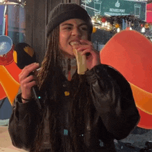 a woman eating a piece of food in front of a sign that says ' wizamel punt ' on it