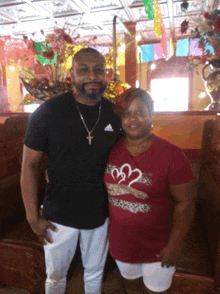 a man and a woman posing for a picture with the man wearing an adidas shirt