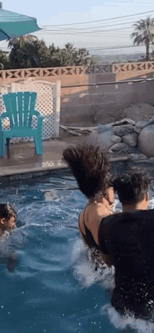 a group of people are playing in a pool with a blue chair in the background