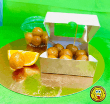 a box of orange balls sits on a gold plate