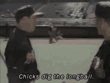 two men are standing on a baseball field talking to each other and one of them is saying `` chicks dig the longball '' .