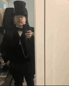 a man in a top hat and bow tie takes a selfie