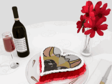 a heart shaped cake sits next to a bottle of wine and a glass of wine