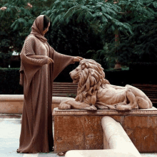 a woman standing next to a lion statue