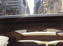 a view of a city from inside a car with the roof open