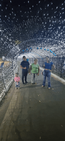 a family posing for a picture in front of a tunnel of lights