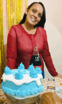 a woman is standing next to a cake and a bottle of 1.25 litros