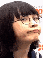 a young girl wearing glasses is making a funny face .