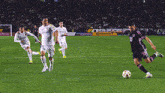 a group of soccer players are playing on a field with a sign that says ' nbc ' on it