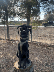 a black dog wearing a police harness sits on a stump