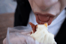 a person eating a piece of cake with their tongue sticking out