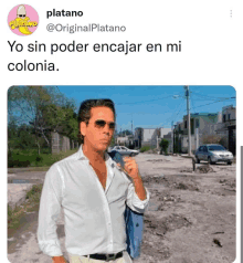 a man in a white shirt and sunglasses is standing on a dirt road with the words yo sin poder encajar en mi colonia