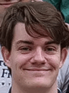 a close up of a young man 's face smiling .