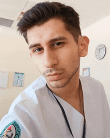 a man wearing a white scrub with a badge that says ' istanbul üniversitesi '