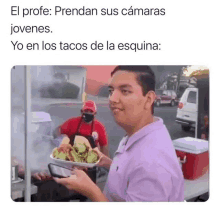 a man in a purple shirt is holding a plate of tacos and a phone