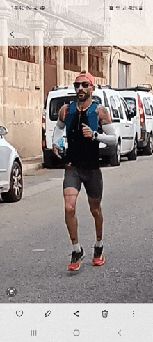 a man is running down a street with a cell phone displaying the time as 14:40