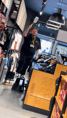 a man in a black shirt is holding a hammer in a store