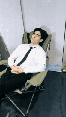 a man in a suit and tie is sleeping in a chair