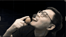 a man wearing glasses holds an egg in his hand