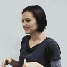 a woman wearing a black shirt is smiling and holding a red marker