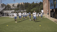 a group of soccer players are running on a field with a building in the background that says ' argentina ' on it