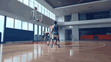 a group of men are playing basketball on a court with a scoreboard that says ' nn ' on it