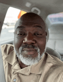 a man with a beard is sitting in a car with his eyes closed