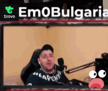 a man is sitting in front of a microphone in a room with the words emobulgaria behind him