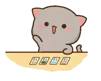 a cat is sitting at a table with cards on it