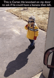 a little boy is eating a banana while wearing sunglasses