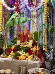 a statue of ganesha is surrounded by flowers and a banana leaf