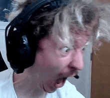 a man wearing headphones and making a funny face .