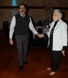 a man and a woman are holding hands and dancing on a dance floor