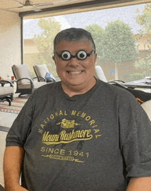 a man wearing glasses and a national memorial shirt