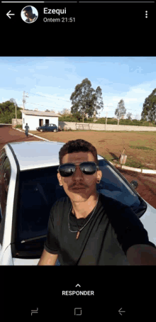 a man wearing sunglasses and a mustache is taking a selfie with ezequi