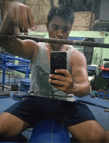 a man taking a picture of himself in a gym with his phone