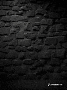 a photo of a black brick wall with the photoroom logo on the bottom right