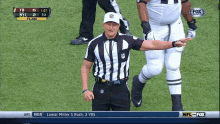 a referee stands on the field during a football game between the new york jets and the green bay packers