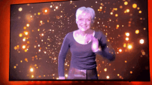 a woman dancing on a television screen with a red background