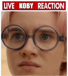 a woman wearing glasses with a live koby reaction sign above her