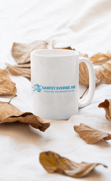 a white coffee mug with the word sanitet sverige ab on it