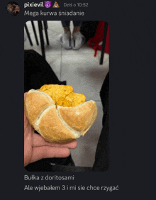 a screenshot of a person holding a sandwich that says pixievil mega kurwa sniadanie