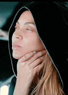 a close up of a woman wearing a black hood