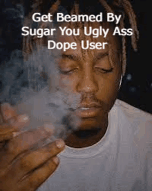 a man with dreadlocks is smoking a cigarette and says `` get beamed by sugar you ugly ass dope user '' .