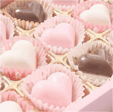 there are many different types of chocolates in the shape of hearts in a pink box .