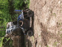 a man is riding a polaris atv near a waterfall