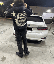 a man standing in front of a white bmw car