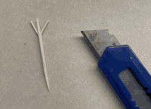 a toothpick next to a knife with a sharp blade