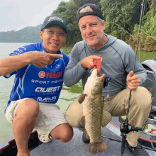 a man in a blue shirt that says yamaha sport fishing is holding a large fish