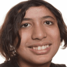 a young boy with long hair is smiling for the camera